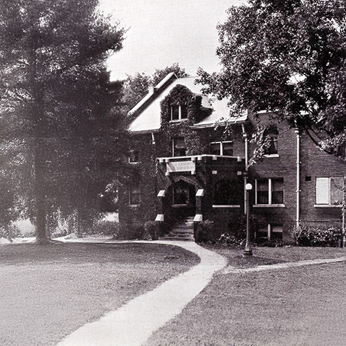 Murrell Library & Academic Support Center Archival photo of a brick campus building at the end of a curving sidewalk.